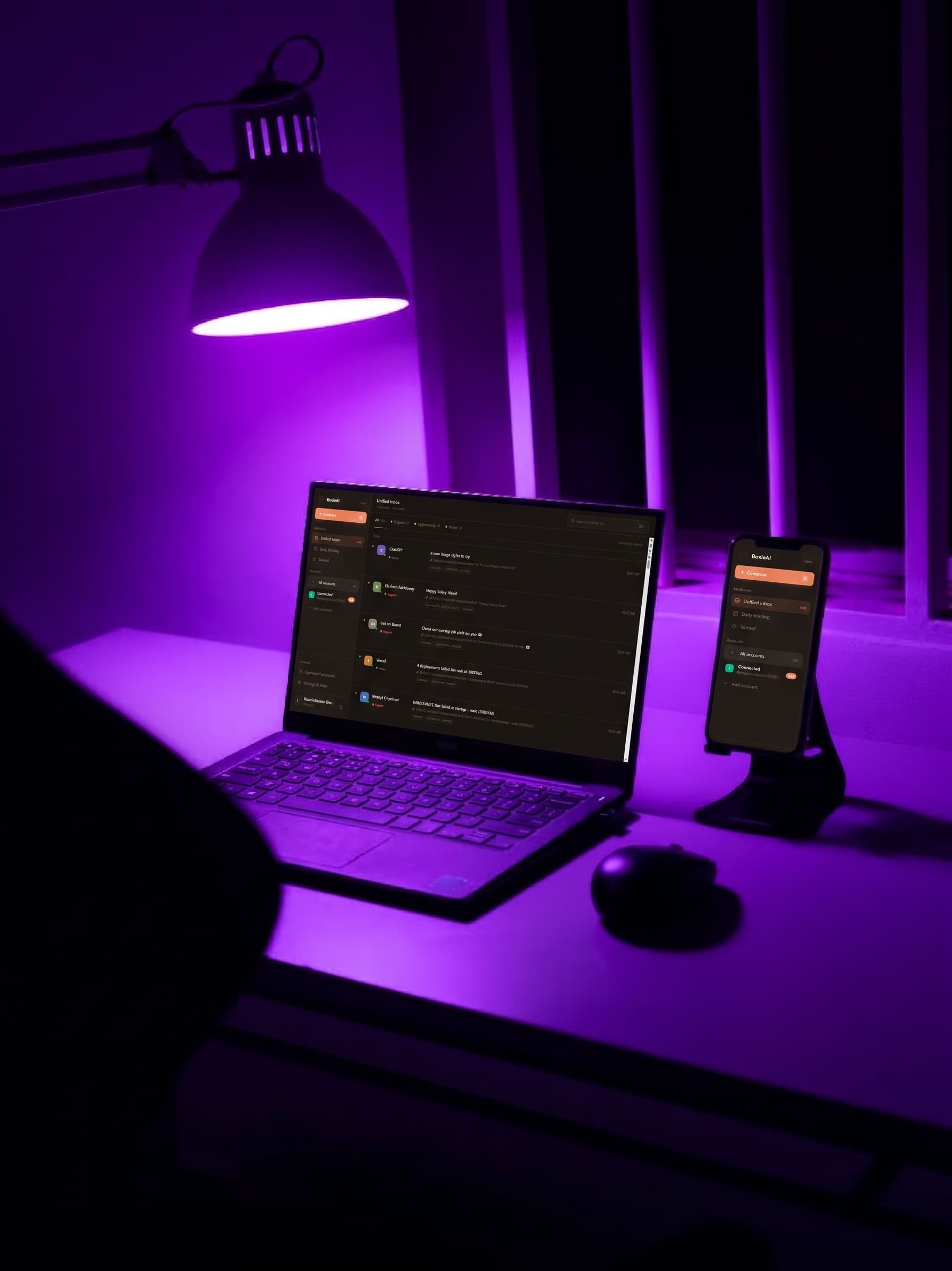A laptop and phone on a desk showing the BoxieAI app